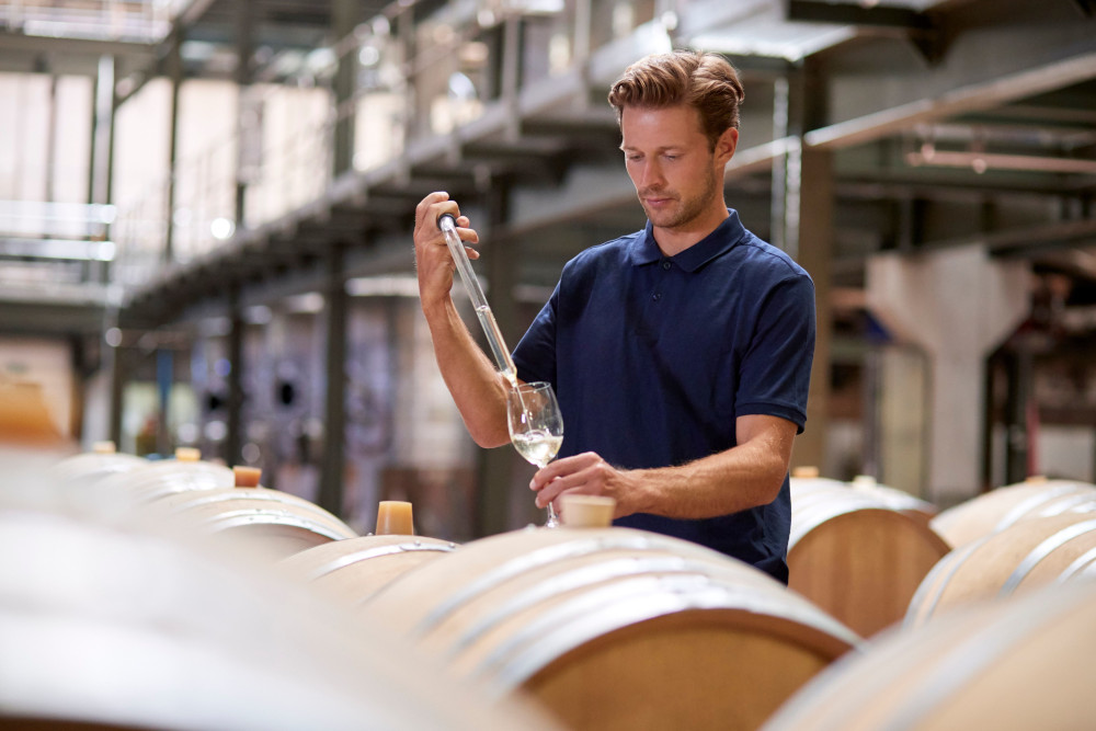 man sampling whisky from barrel