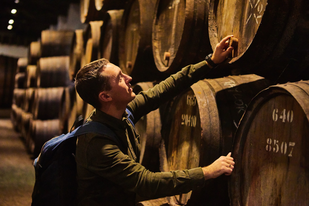 man checking whisky barrel
